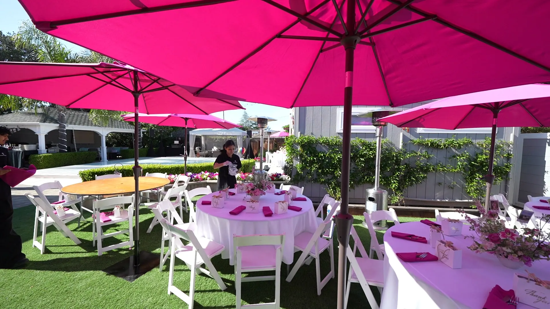 Lawn tables under bright umbrellas at an East Palo Alto backyard party
