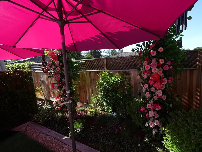Floral arch beside umbrella seating at a Portola Valley backyard event